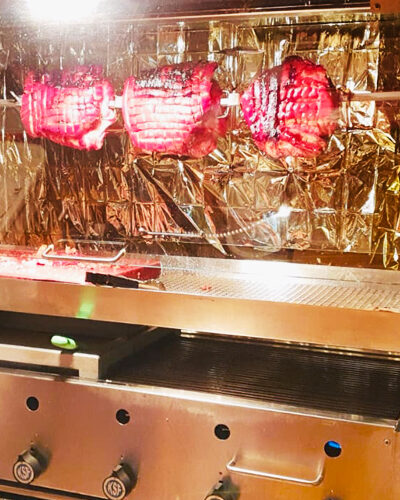Spanferkel dreht sich langsam am Grillspieß